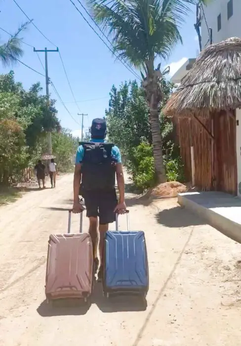 dragging bags through Isla Holbox's dusty streets
